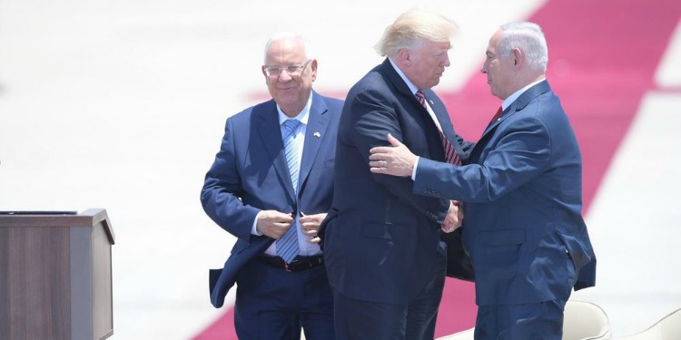 Rivlin standing to the side smiling while Trump and Bibi shake hands.