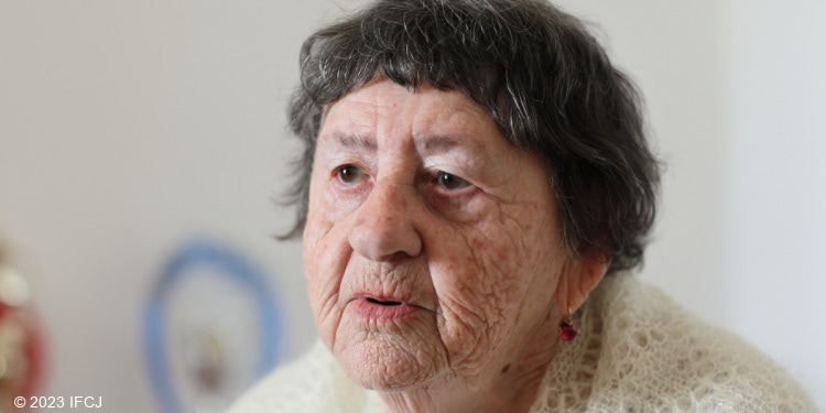 Elderly Jewish woman in white sweater looking sad