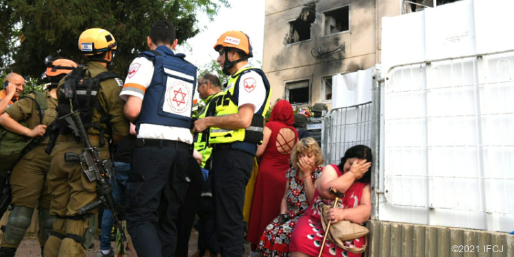 IDF officers standing outside of Ashkelon building damaged by missile fire