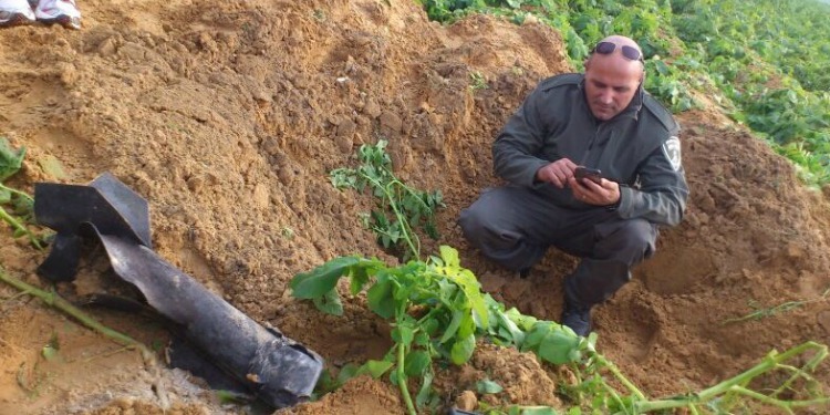 A man taking pictures of a rocket in a hole it created.