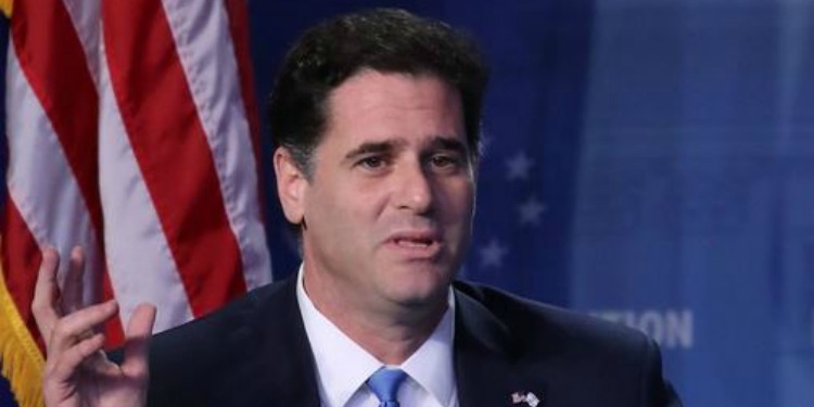 Ron Dermer talking while the American flag is behind him.
