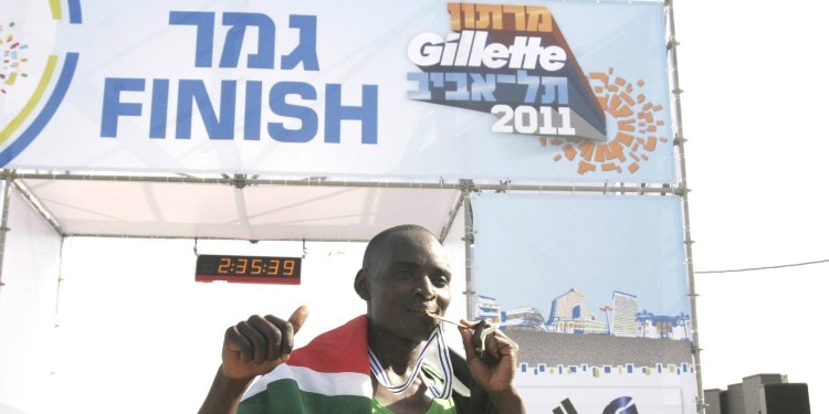 Kenyan runner Josphat Kipkemboi Ronoh kissing his winner's medal in the 2011 Tel Aviv marathon.