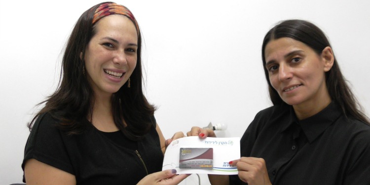 Yael Eckstein holding an IFCJ branded credit card next to a young woman.