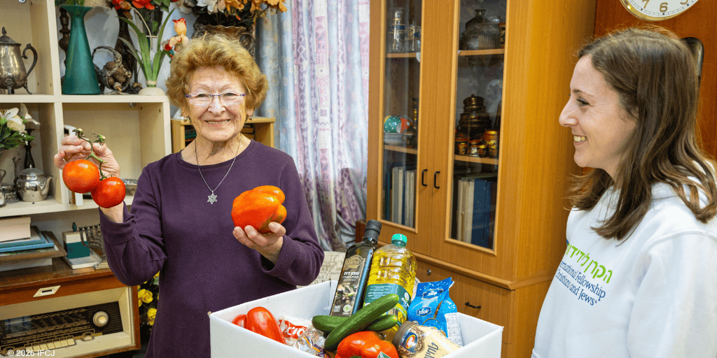 Older woman and young woman with vegetables in a home setting.