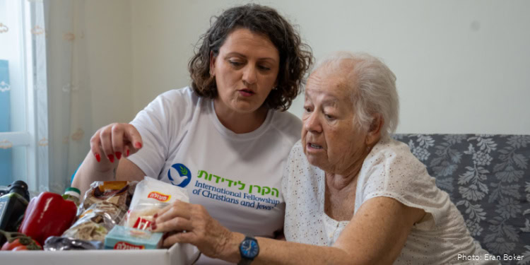 A young woman providing care and support to an elderly woman at home, demonstrating compassion and assistance with daily activities.