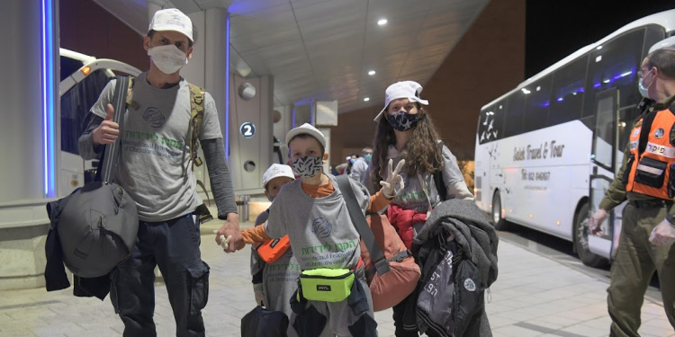 The Evsikov family with masks on looking towards the camera.