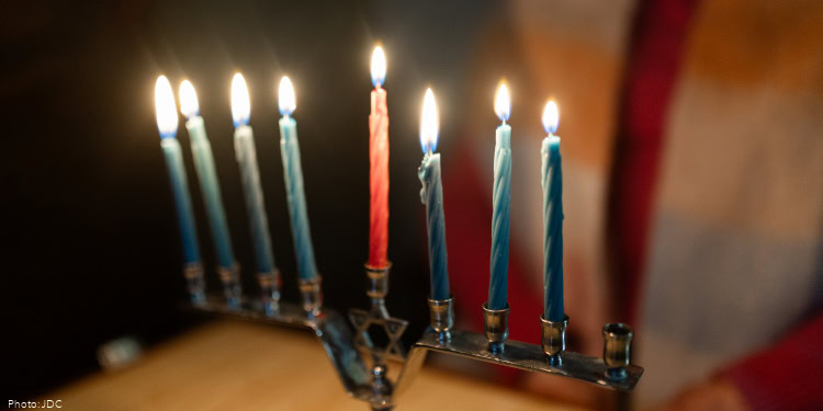 Visit to Faina Melnik - JDC beneficiary - Kishinev, Moldova - November 14, 2024 menorah with lit candles, Hanukkah