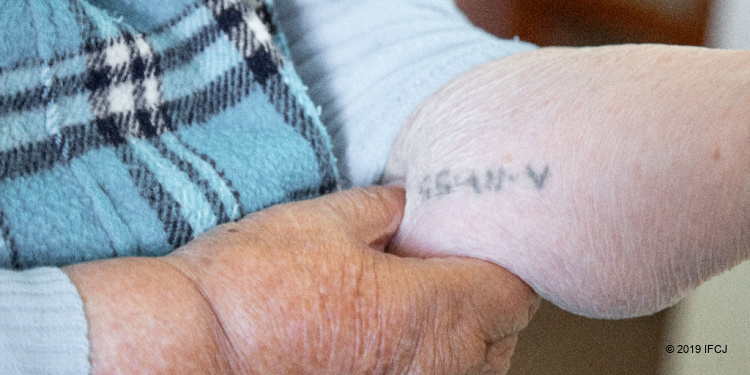 Elderly Holocaust survivor tattoo on arm