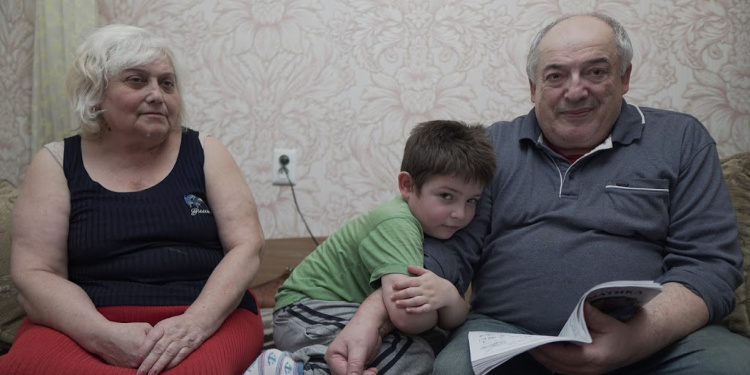 Young Ukrainian Jewish boy, Ilya, alone with his grandparents