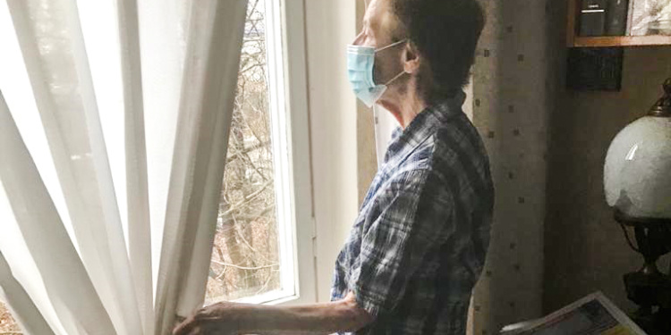 Elderly Holocaust survivor Irina looks out window in fear