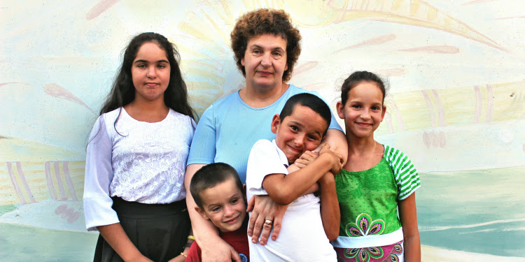 The Kochnev Family in front of a painted wall.