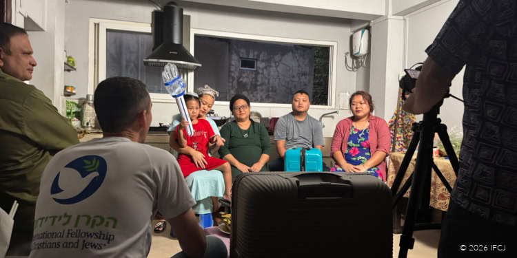 Celebrating 35 years of waiting, a family gathers indoors, expressing joy and gratitude, symbolizing hope, faith, and the power of community support through IFCJ initiatives.