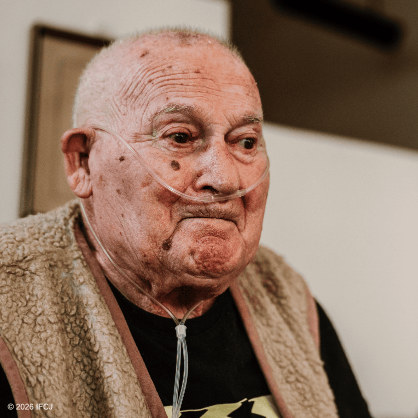 Elderly man with oxygen tube in a care setting, symbolizing compassion and support for seniors.