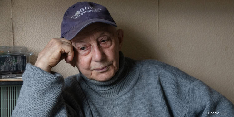 Elderly man receiving food and supplies from IFCJ volunteers in Israel, demonstrating compassion and support for vulnerable seniors in need.