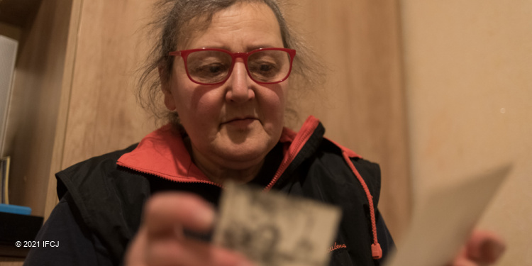 Maria Izailevskaya, an elderly Jewish woman in glasses going through family photographs.