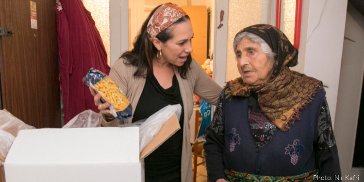 Yael Eckstein standing with elderly recipient