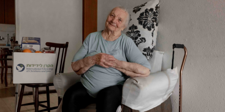 Elderly With Dignity and Fellowship recipient receives a Passover food box.