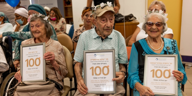 Three elderly Jewish people sitting next to each other celebrating their 100th birthday.