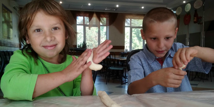 Two young Jewish children making food together.