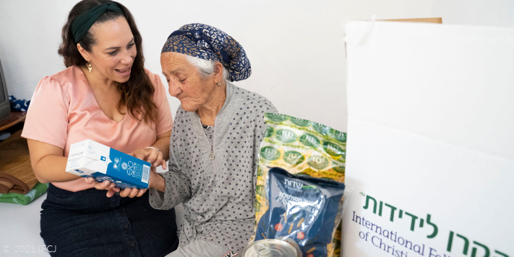Yael Eckstein and elderly woman with food box