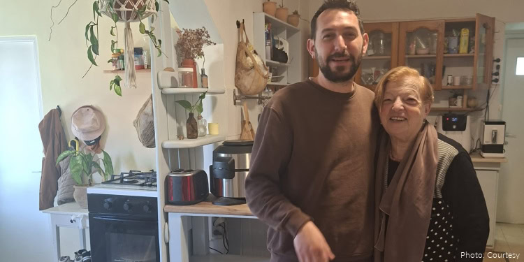 Rosa Abramovich, oleh from Argentina, and her son. adult man and elderly woman sanding in kitchen, hugging, group photo