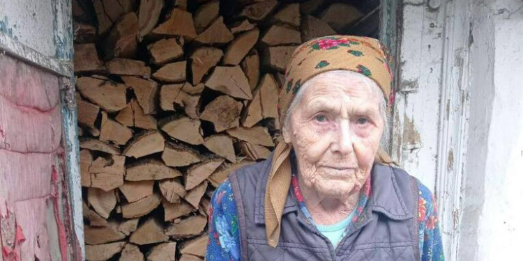 Rosalia, elderly Holocaust survivor in Ukraine with firewood for winter