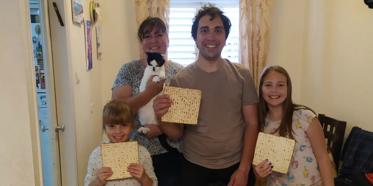 Olim family holding Matazah and smiling.