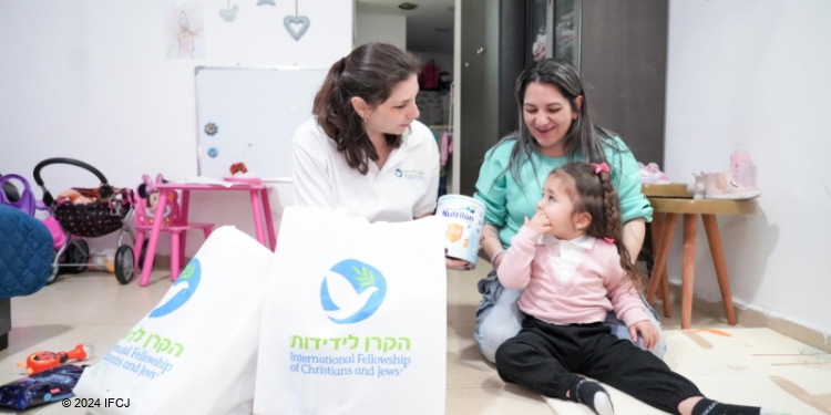 Mother and 3-year-old daughter receive Passover food from The Fellowship.