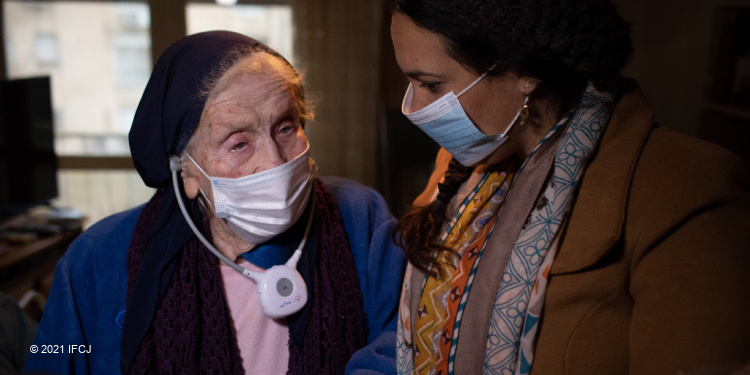 An elderly Jewish woman and Yael Eckstein in masks.