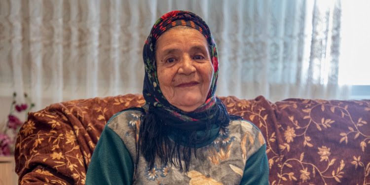 Sibo Shuminov sitting on a couch looking directly at the camera.