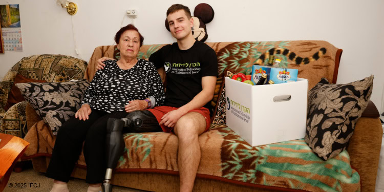 A man, with a prosthetic leg, sitting on a couch with an elderly woman sitting next to him.