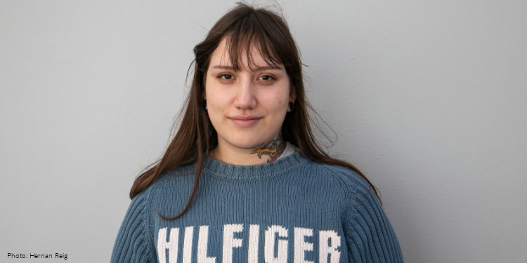 Valentina Flores (oleh) - Buenos Aires, Argentina - September 7, 2025 young woman in blue sweater with HILFIGER logo on white letters - looking at camera