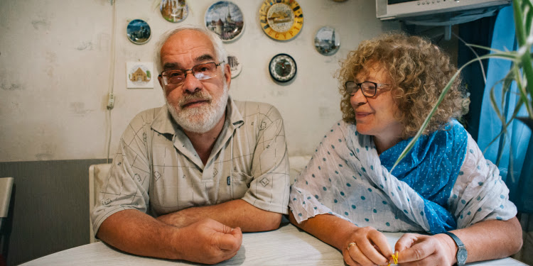 Vladimir Pivovarov with a woman sitting next to him as he tells a story.