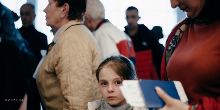 Ukrainian olim girl surrounded by women while making aliyah