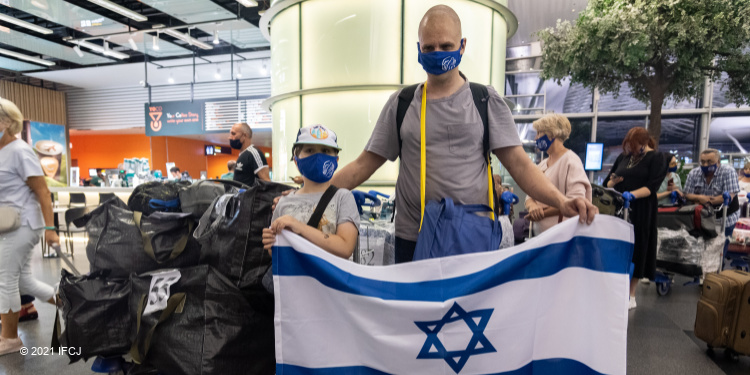 Man and a child holding up an Israeli flag.