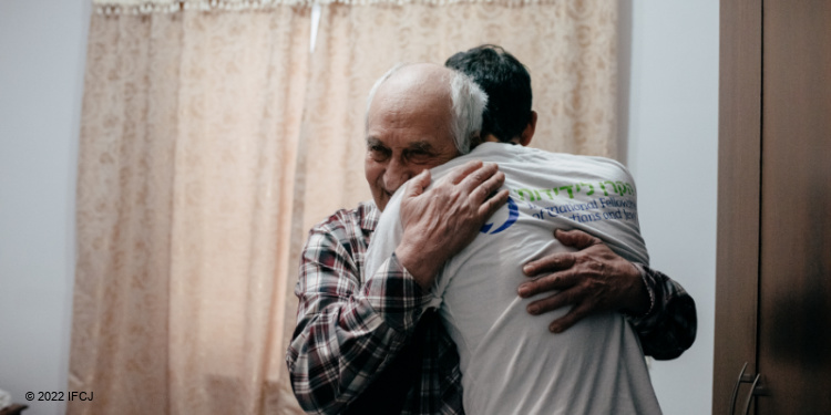 Zinovii, a Ukraine refugee who made aliyah with the Fellowship hugging an IFCJ volunteer.