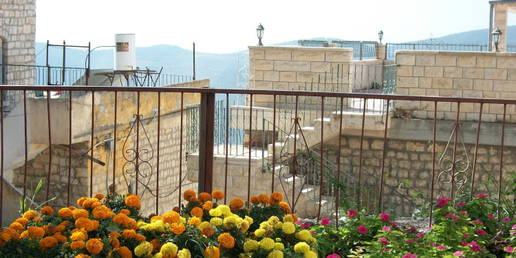 Balcony filled with orange, yellow, and pink flowers.