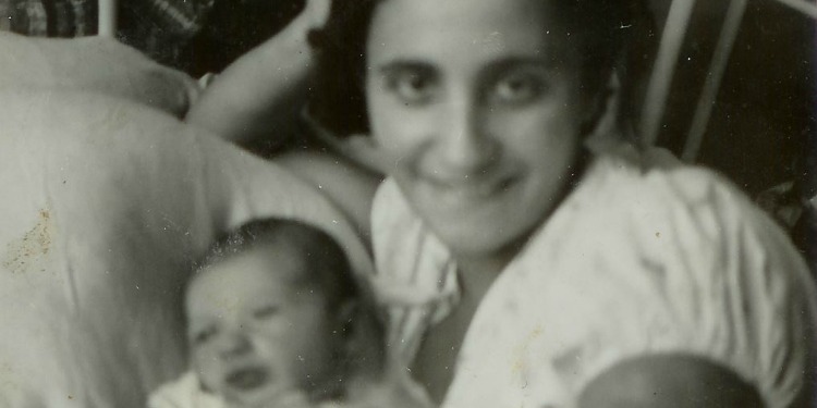 Black and white image of a woman smiling with her baby.