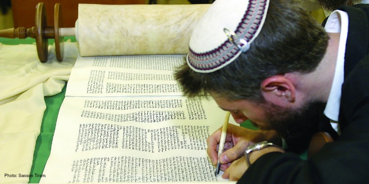 Man writing on an open scroll.