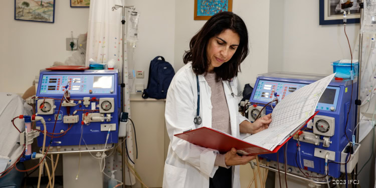Schneider Children’s Medical Center of Israel, Project: Fortification of the Children’s Dialysis Unit, doctor stands with chart next to machines, lab coat, stethoscope, hospital