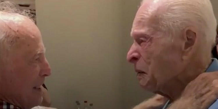 Screen capture of two elderly men embracing each other and crying.