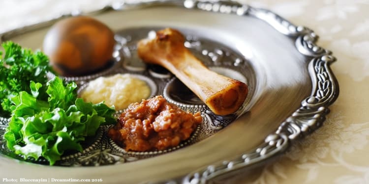 Seder plate with shank bone, egg, bitter herbs, and other food items.