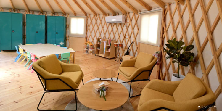 Interior view of the expanded Trauma Center at Sha’ar HaNegev with yurt, featuring seating area, wooden walls, and medical storage units.