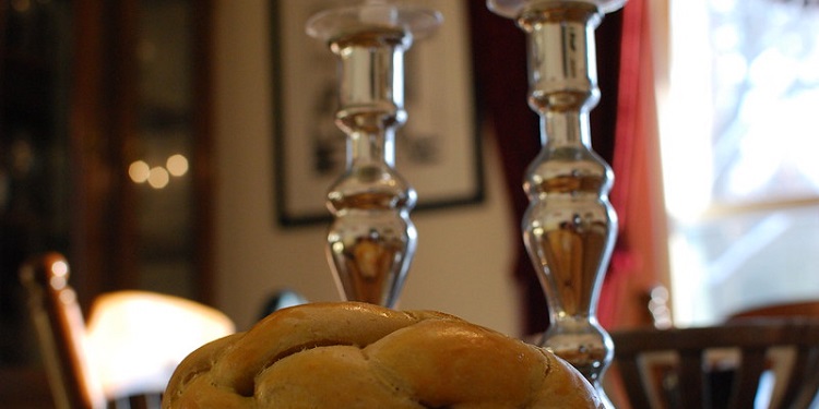 Shabbat candles in front of baked rolls