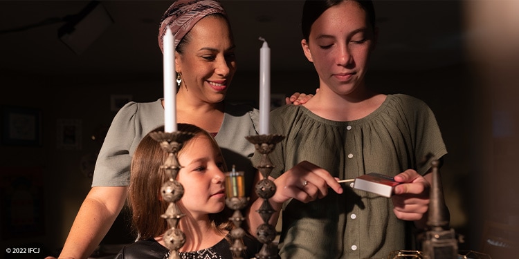 Yael Eckstein and her daughters light the Shabbat candles.