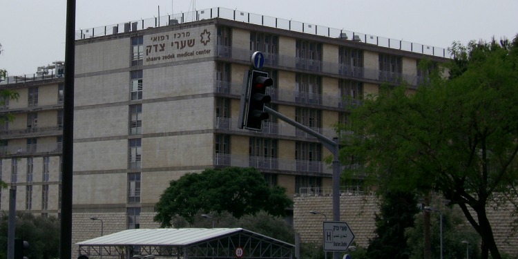 The building of the Tzedek Hospital with several trees around it.