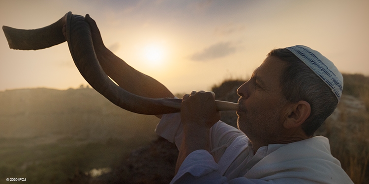 Ed Kruger, Jewish man blowing the shofar in a quarry outside Shuni Park near dawn. Ram's horn. Kippah.