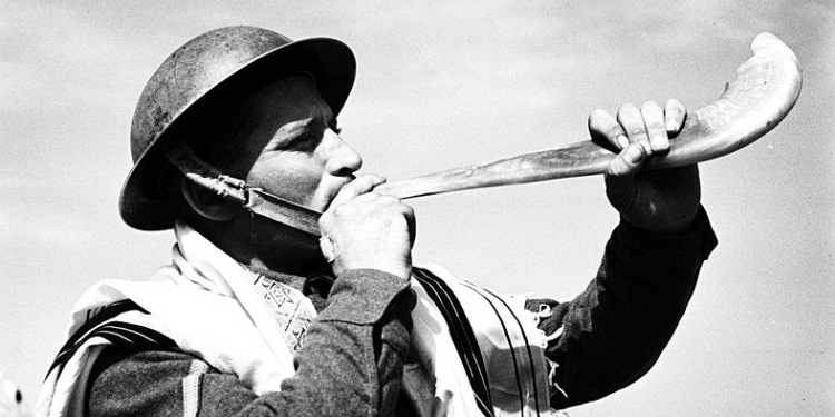 Jewish soldier in Holy Land blows shofar, trumpet made from ram's horn, 1941