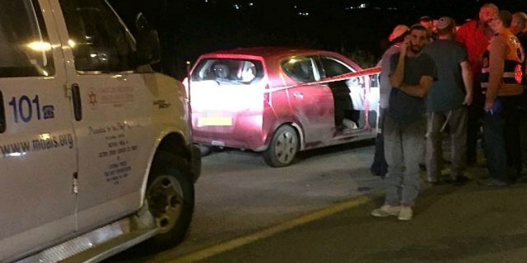 Several civilians standing on the side of a highway who witnessed the killing of a Rabbi.