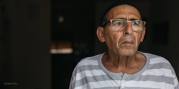 Elderly man wearing gray and white striped shirt.